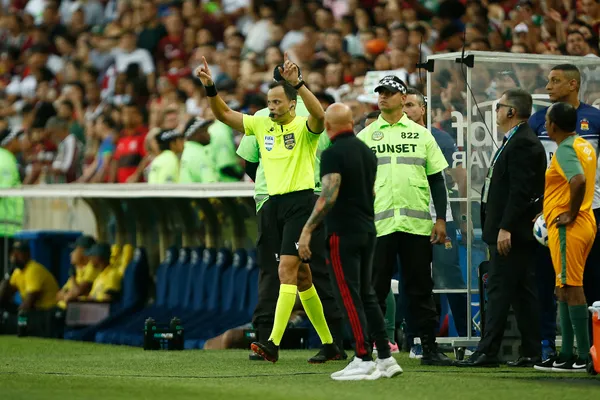 RIO DE JANEIRO, BRAZIL - JULY 16: Referee Savio Sampaio annuls the first goal of Fluminense goal after checking with VAR officials during a match between Fluminense and Flamengo as part of Brasileirao 2023 at Maracana Stadium on July 16, 2023 in Rio de Janeiro, Brazil. (Photo by Wagner Meier/Getty Images)