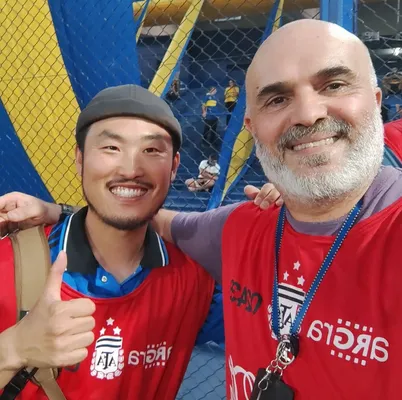 Wonyoung Choi junto al fotógrafo Gerónimo Marino en La Bombonera.