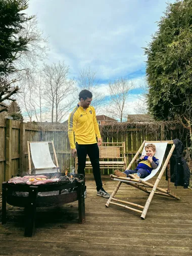 Moroni junto a su hijo en su casa vistiendo la indumentaria de Boca